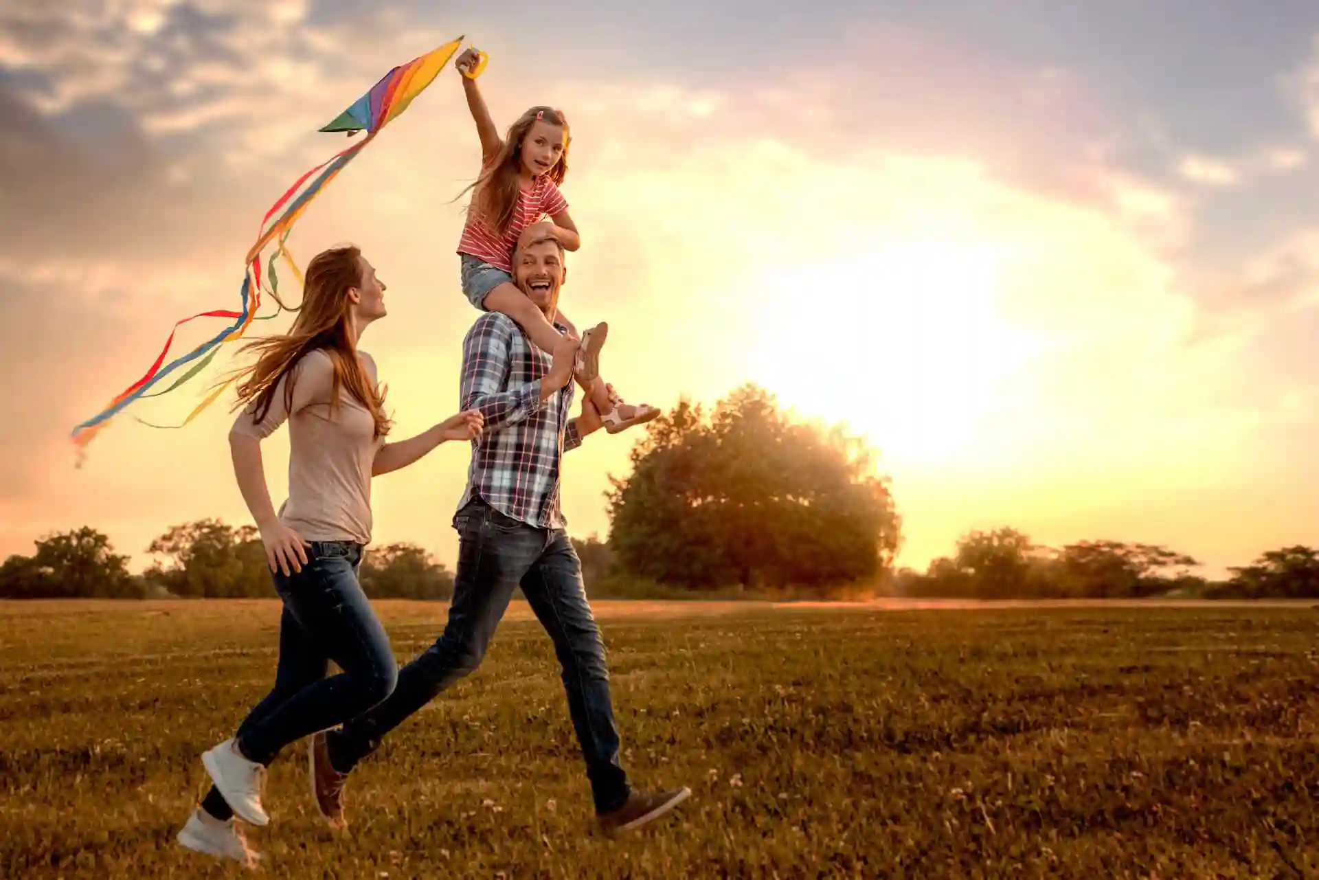 une famille se promène à la campagne au coucher de soleil